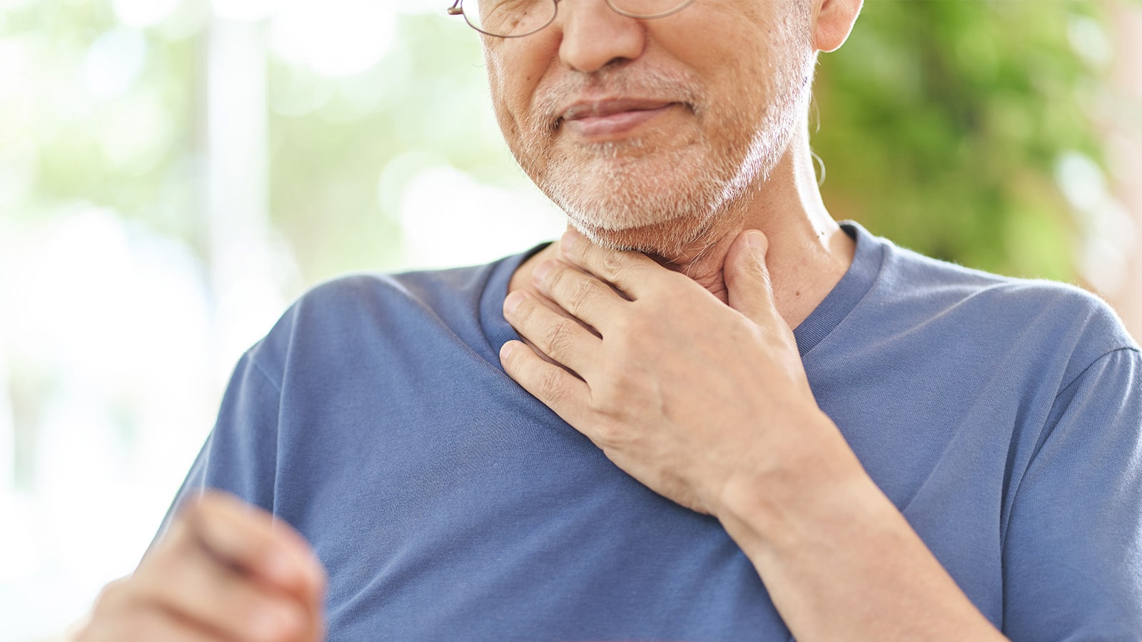 Difficulty Swallowing Elderly man in blue shirt holding his throat
