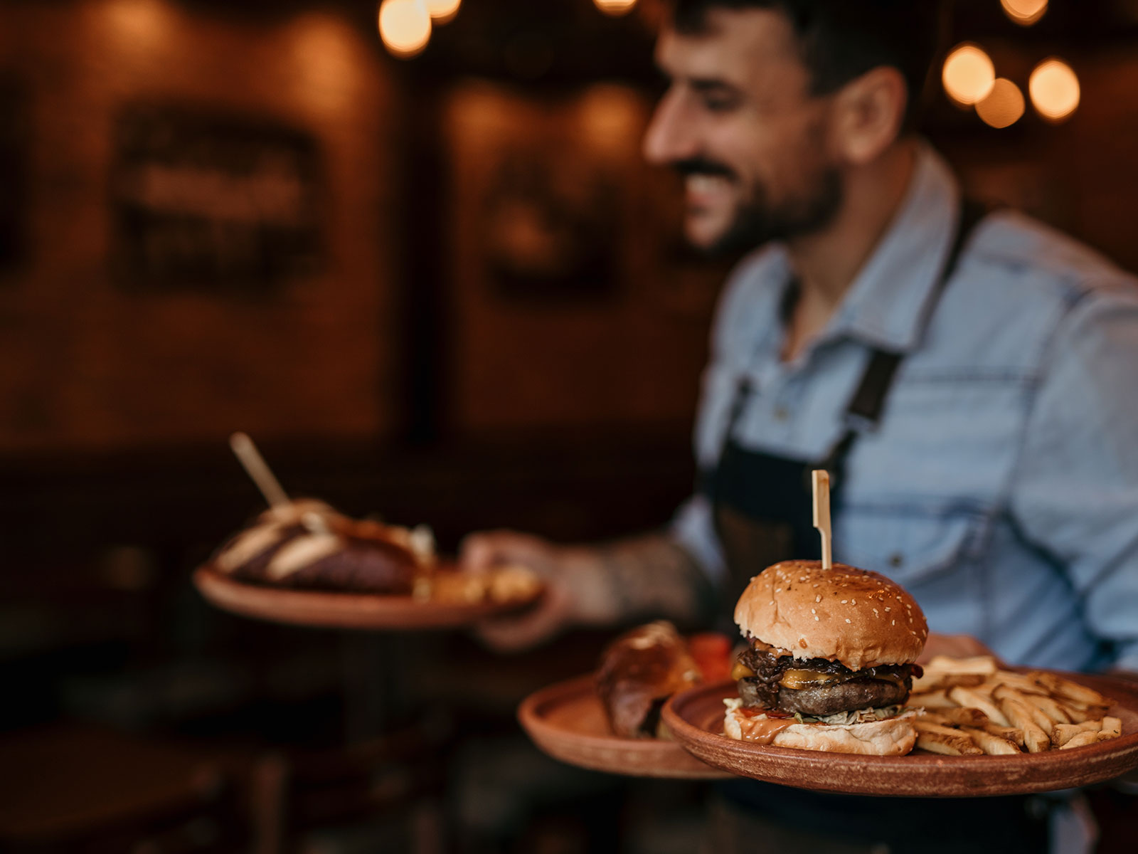Smiling Waiter Smiling waiter holding tray with burger and fries
